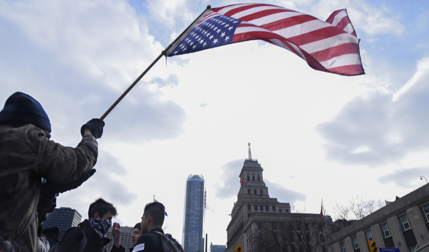 Protesters waiving an American flag during a protest in front of the US Consulate to denounce Donald Trump's immigration policies on February 4, 2017 in Torona