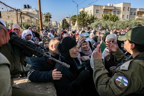 israeli troops control a large group of palestinian woman at gunpoint